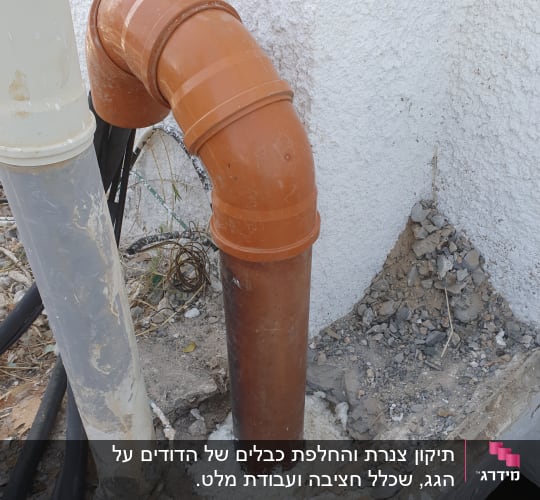 צינור כתום מותקן בקיר עם חיבורי פלסטיק